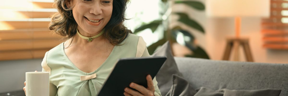 Satisfied Middle Aged Woman Drinking Hot Tea And Using Digital T - Advocacia em Chácara Santo Antônio - SP | Glória Rabelo